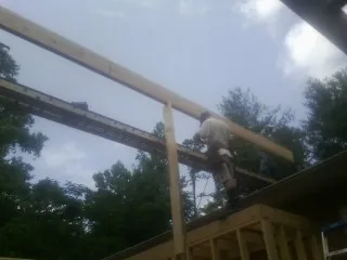Carpenter setting a ridge beam over a new addition frame — Ice Dam Removal by Roofing Brothers in Darden