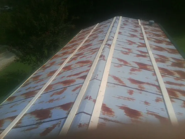 Rusted metal roof panels with new wood purlins before replacement — Storm Damage Roof Repair in Darden by Roofing Brothers