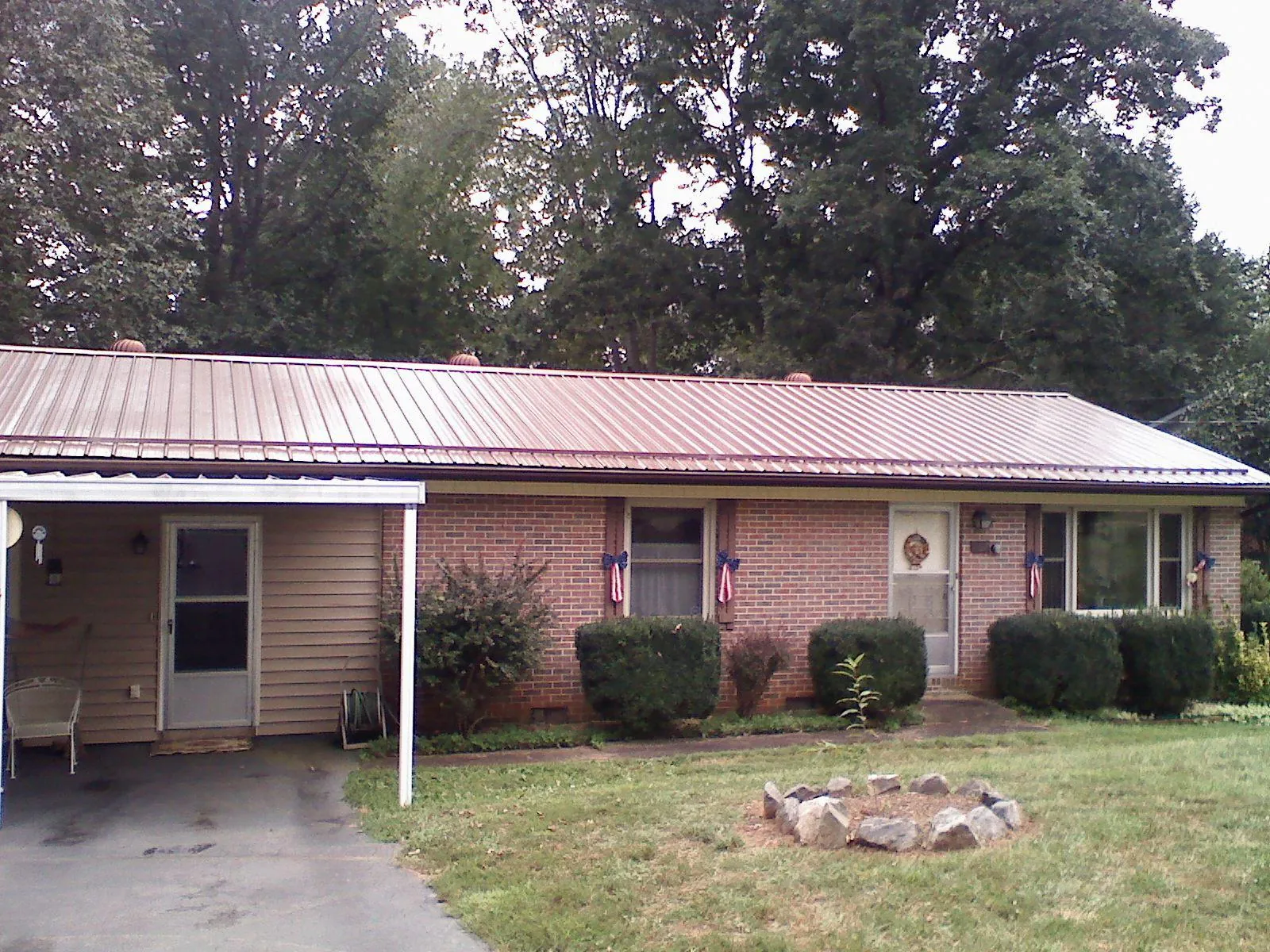 Bronze metal roof and carport on a brick ranch home — Roof Repair work by our crew in Darden