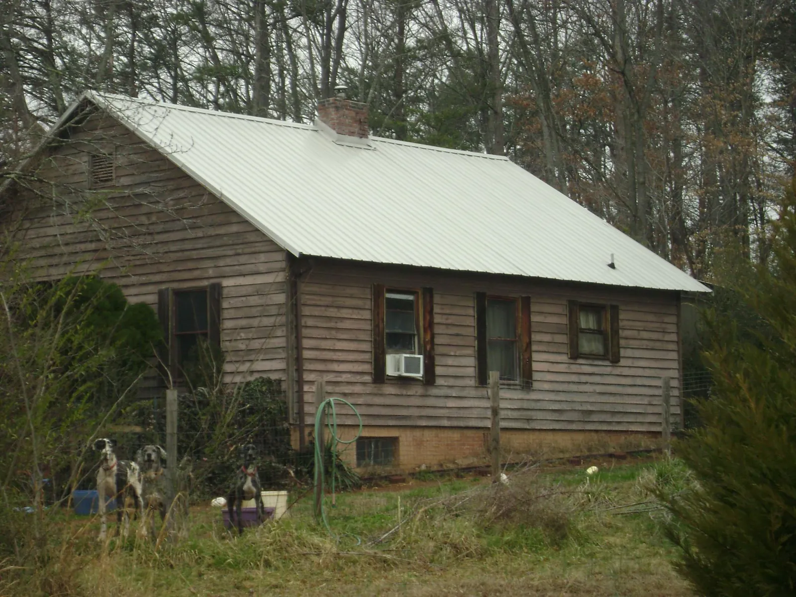 White metal roof on an old wood sided farmhouse, from a Metal Roof Installation job in Darden